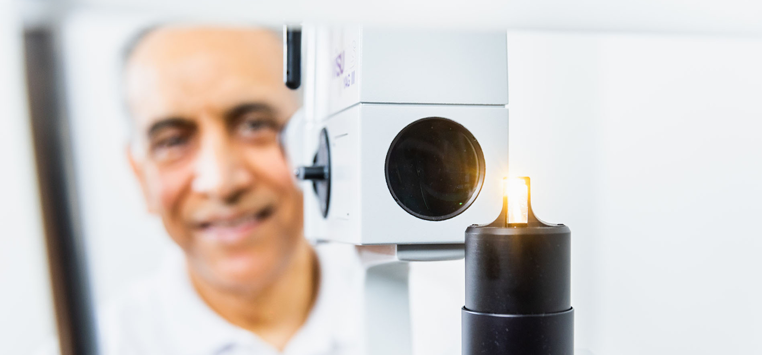 Patient bei der Untersuchung an einem ophthalmologischen Lasergerät (Spaltlampen-/YAG-Lasersystem)